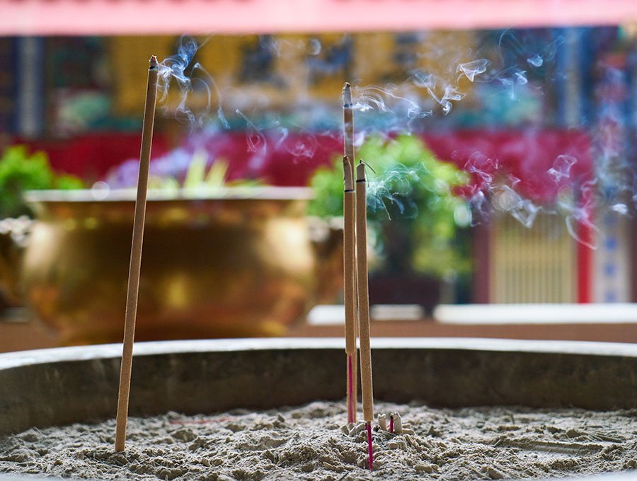 Cuatro varillas de incienso de distinto aroma encendidas en un templo budista.