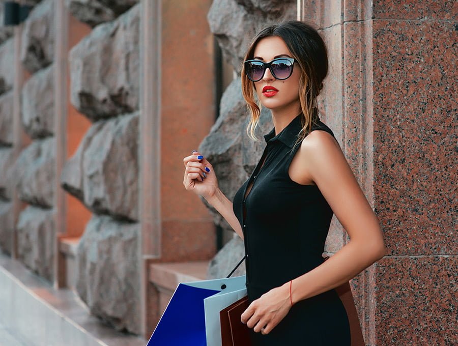 Mujer con vestido negro de moda en la calle.