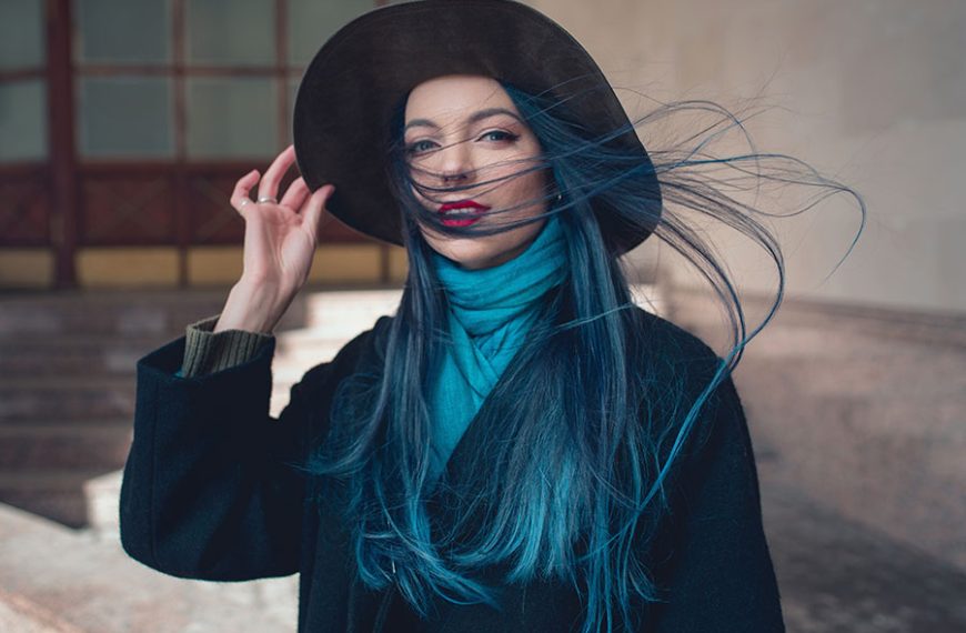 Mujer con sombrero y cabello azulado.