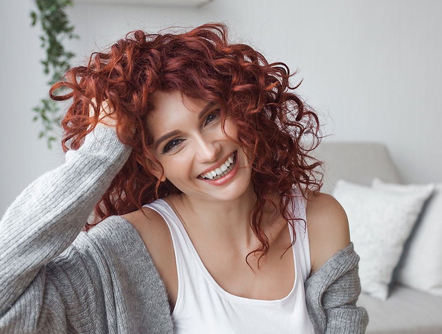 Mujer sonriente con el cabello rojo.