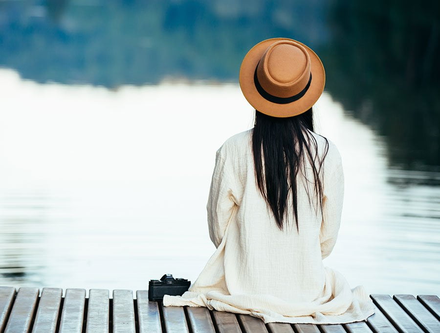 Mujer mirando al lago en la ausencia mental.