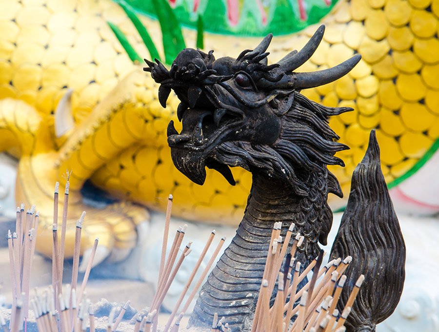 Varitas de jazmín junto a estatua de dragón.