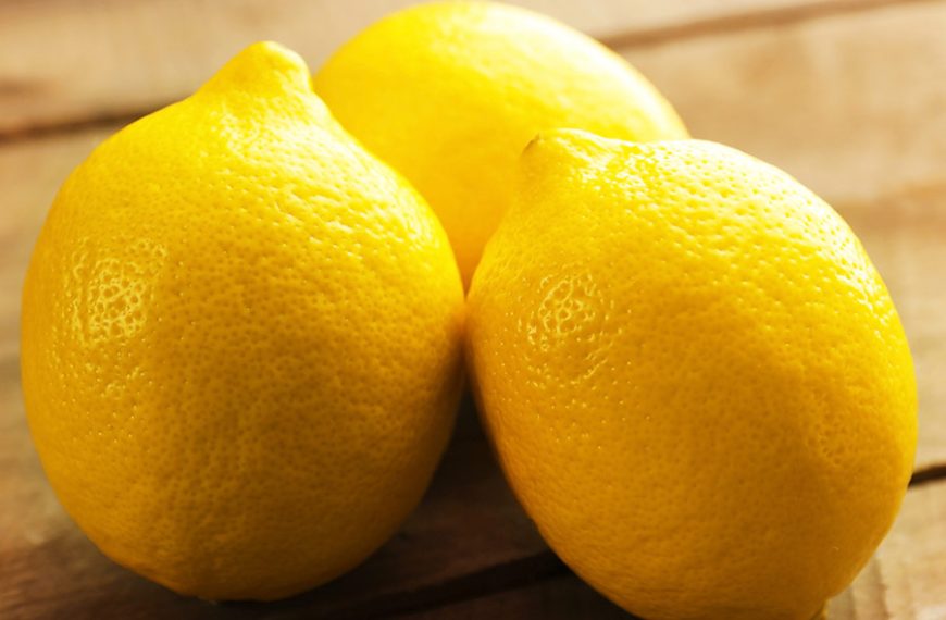 Tres hermosos limones sobre la mesa de madera.
