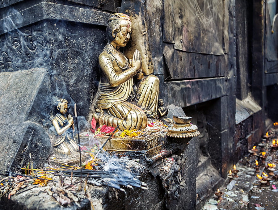 Zona de rezos de un templo hindú. Hay una figura de metal rezando.