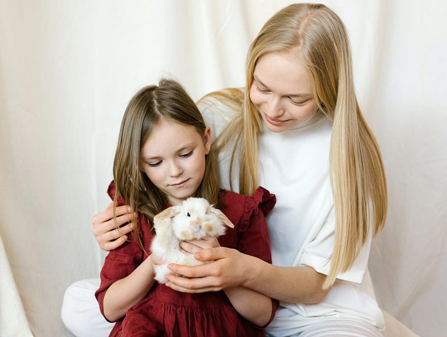 Madre e hija cuidando al conejo mascota.