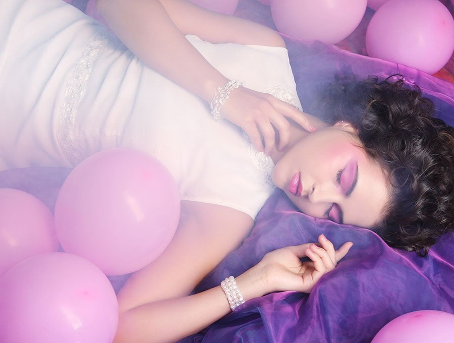 Mujer durmiendo entre globos.